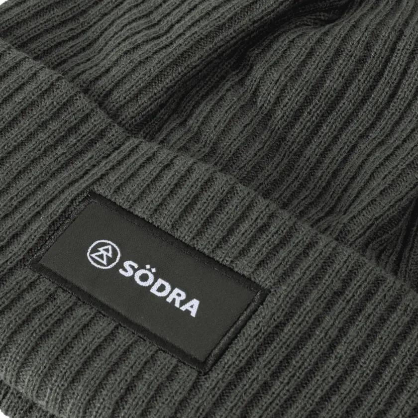 stickad mössa med södra logga närbild